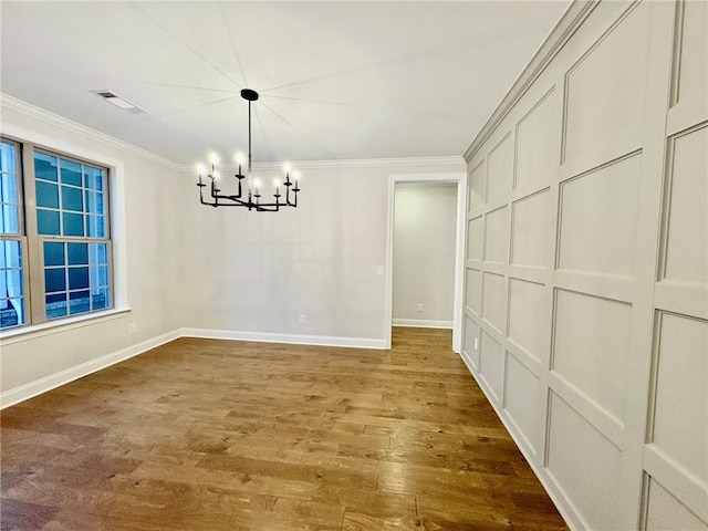 unfurnished dining area with baseboards, visible vents, ornamental molding, wood finished floors, and a chandelier