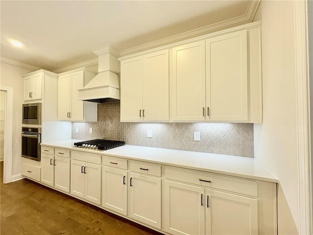 kitchen featuring custom exhaust hood, stainless steel appliances, light countertops, white cabinetry, and backsplash