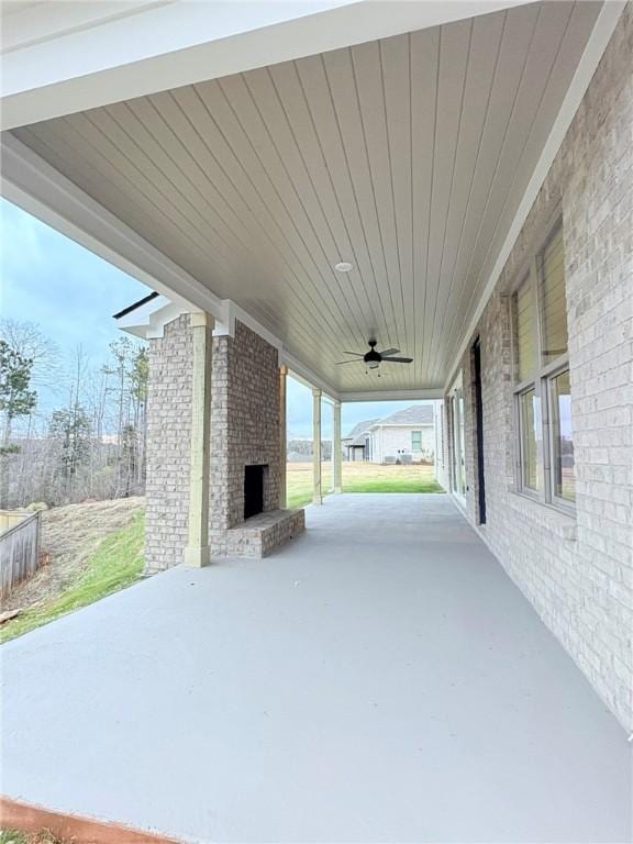 view of patio featuring an outdoor brick fireplace and ceiling fan