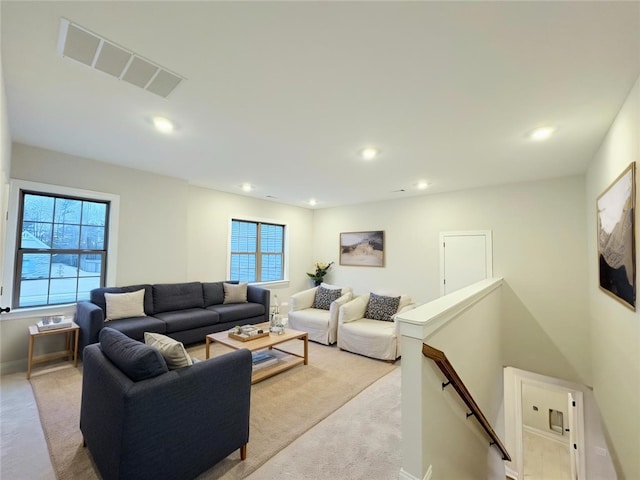 living area featuring recessed lighting, visible vents, light carpet, and baseboards