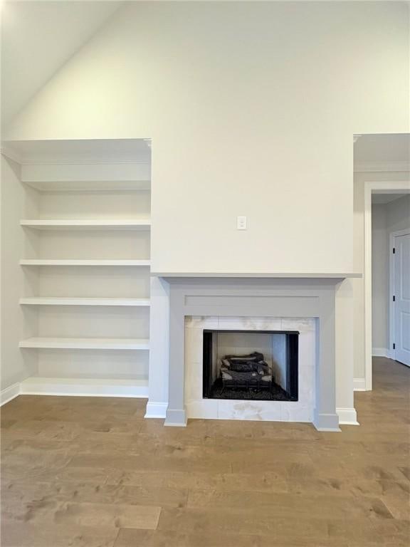 room details with hardwood / wood-style floors and a tile fireplace