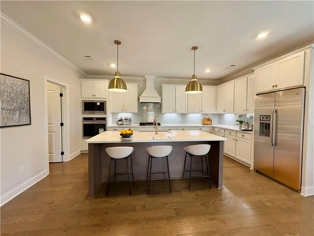 1649 James Burt Pkwy, Auburn, AL 36830 - kitchen featuring stainless steel appliances, custom exhaust hood, white cabinetry, backsplash, and a kitchen island with sink