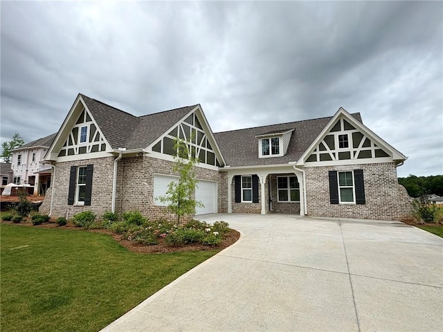 1649 James Burt Pkwy, Auburn, AL 36830 - tudor home featuring brick siding, concrete driveway, a front lawn, an attached garage, and roof with shingles
