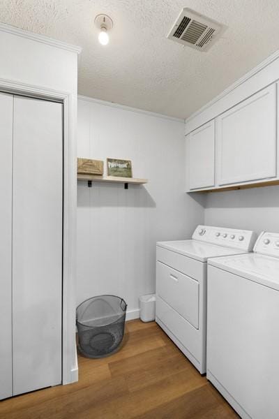 1324 Azalea Dr, Auburn, AL 36830 - washroom featuring cabinet space, washing machine and clothes dryer, light wood-style floors, and a textured ceiling