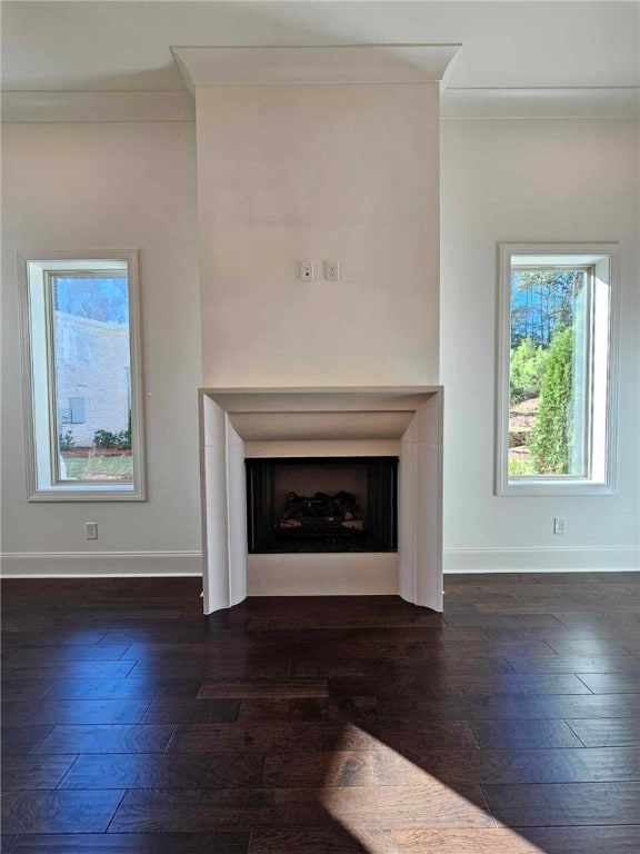 unfurnished living room with dark hardwood / wood-style floors and crown molding