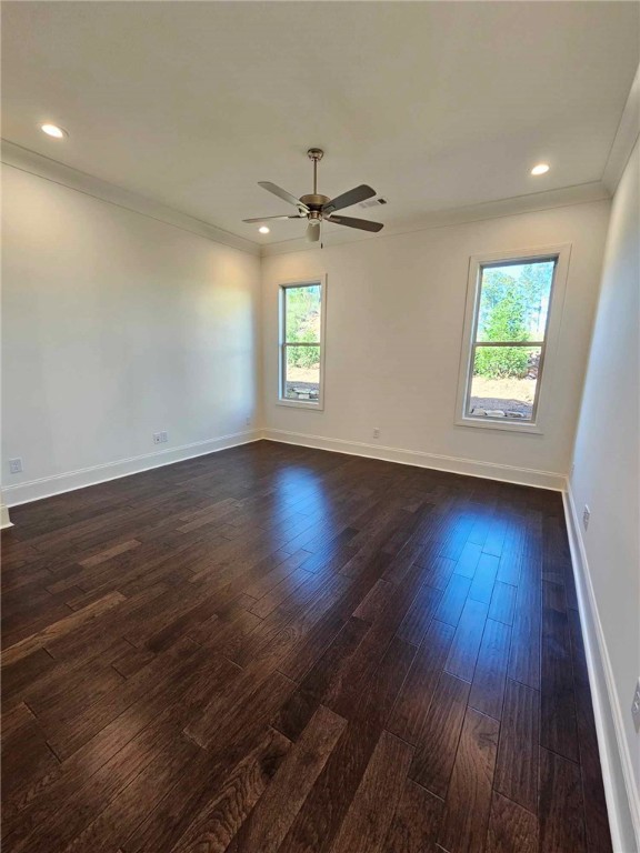 empty room featuring ceiling fan, dark hardwood / wood-style flooring, and ornamental molding