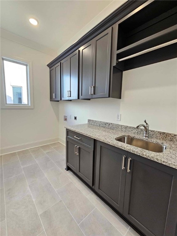 kitchen with light stone countertops, light tile patterned floors, and sink