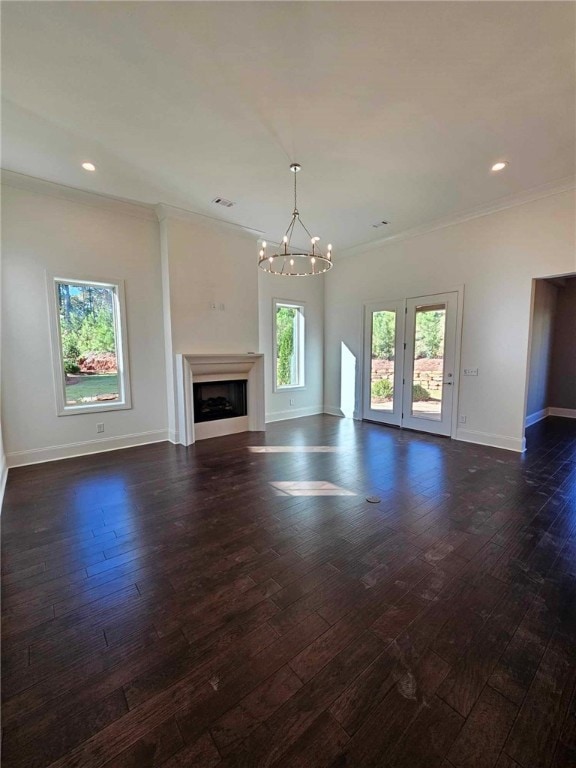 unfurnished living room featuring ornamental molding, dark wood-type flooring, and a notable chandelier