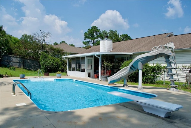 view of pool featuring a fenced in pool, a sunroom, fence, a water slide, and a diving board