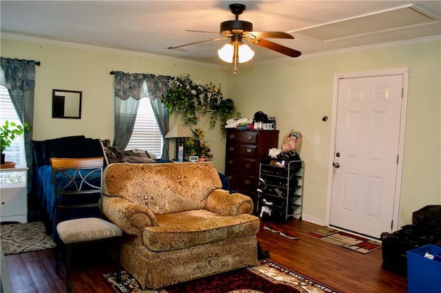 living room featuring ornamental molding, attic access, a ceiling fan, wood finished floors, and baseboards