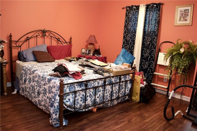 bedroom with dark wood-type flooring and baseboards