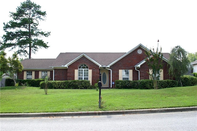 ranch-style home featuring a front lawn and brick siding