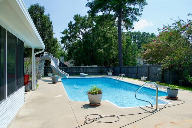 view of pool with a patio, a water slide, a fenced backyard, and a fenced in pool