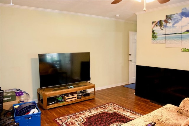 living room featuring baseboards, a ceiling fan, dark wood finished floors, and crown molding