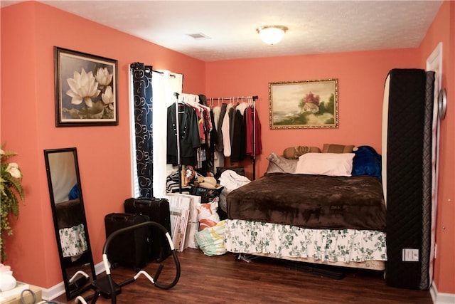 bedroom featuring dark wood-style floors, visible vents, and baseboards