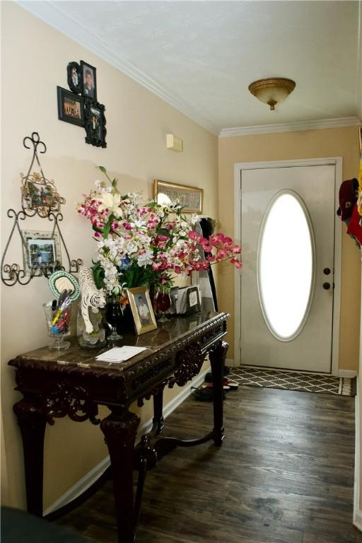 foyer with ornamental molding and dark wood-type flooring