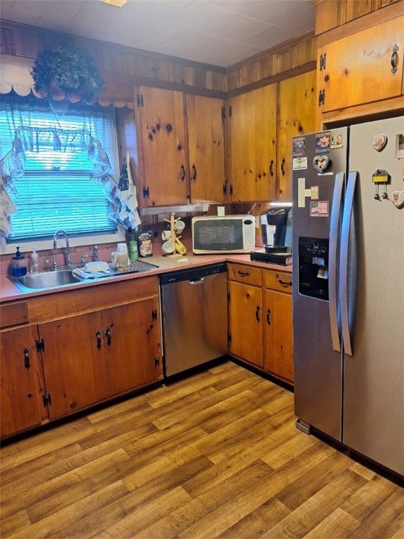 1701 53rd St, Valley, AL 36854 - kitchen with stainless steel appliances, light wood-style flooring, brown cabinetry, and light countertops