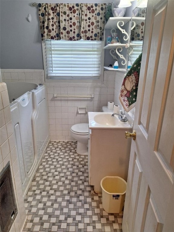 1701 53rd St, Valley, AL 36854 - bathroom featuring vanity, tile walls, a stall shower, a bathtub, and wainscoting