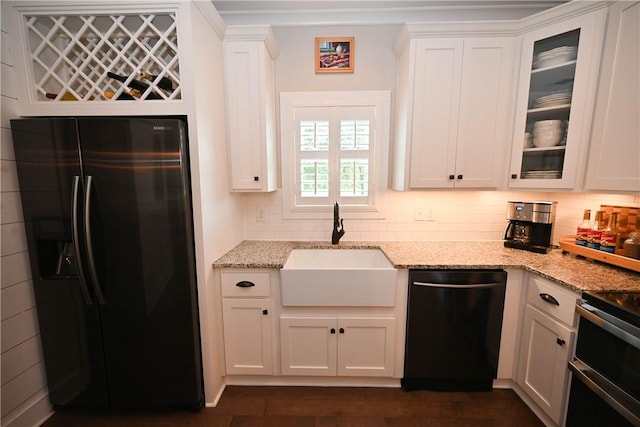 kitchen featuring light stone counters, black dishwasher, stainless steel fridge with ice dispenser, and white cabinets