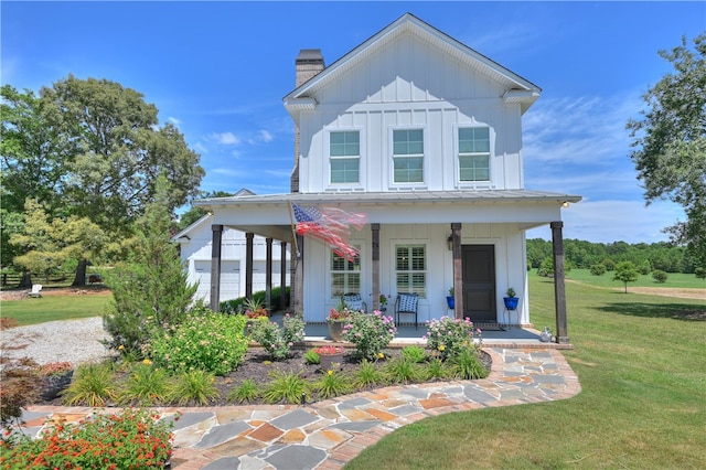 view of front facade featuring a porch, a garage, and a front yard