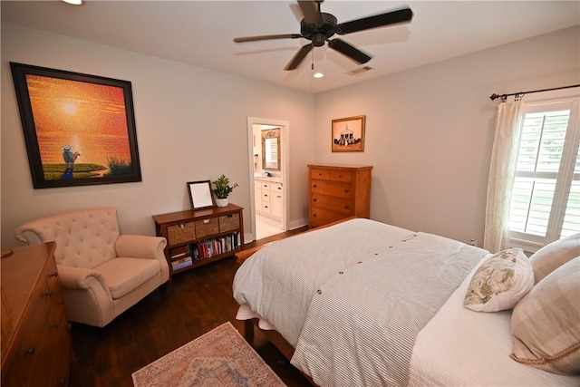 bedroom featuring dark hardwood / wood-style flooring, ensuite bath, and ceiling fan