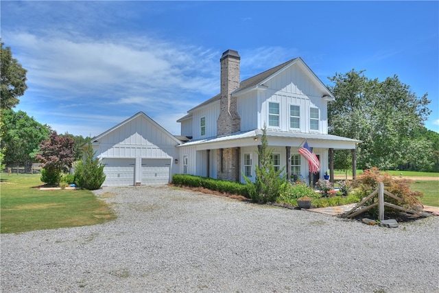 view of front of home featuring a garage, a front yard, and a porch