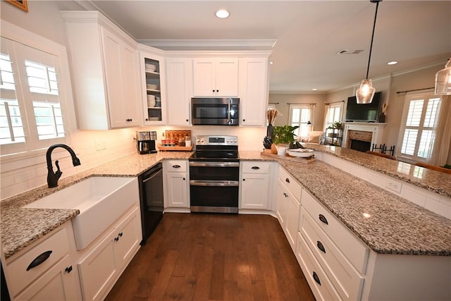 kitchen featuring sink, stainless steel appliances, hanging light fixtures, and white cabinets