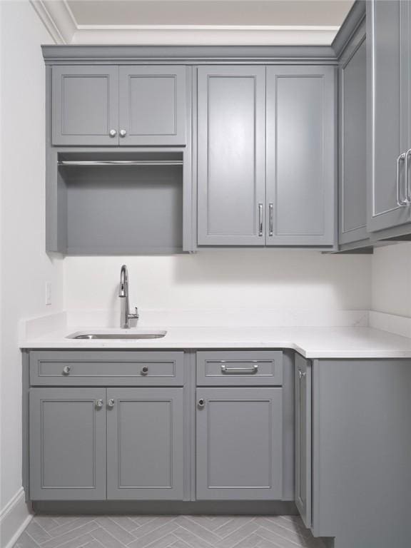 interior space featuring sink, gray cabinets, and ornamental molding