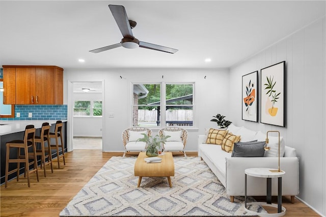 living room with ceiling fan and light hardwood / wood-style flooring