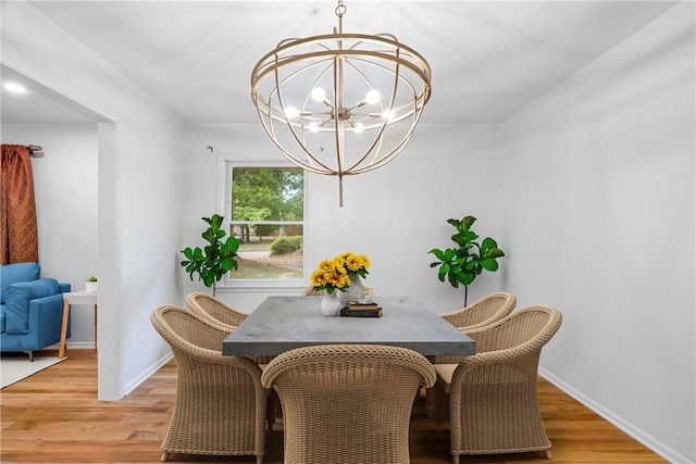 dining space featuring light hardwood / wood-style flooring and a notable chandelier