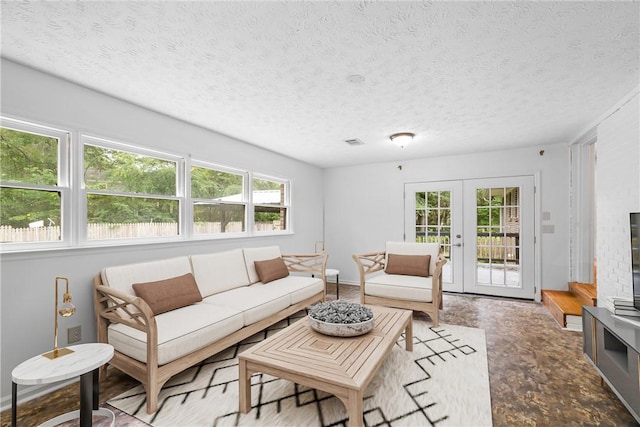 living room featuring french doors and a textured ceiling