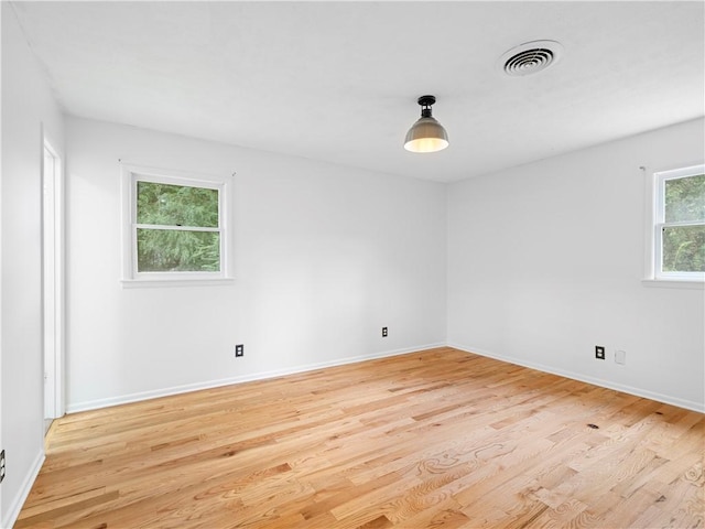 unfurnished room with a wealth of natural light and light hardwood / wood-style floors