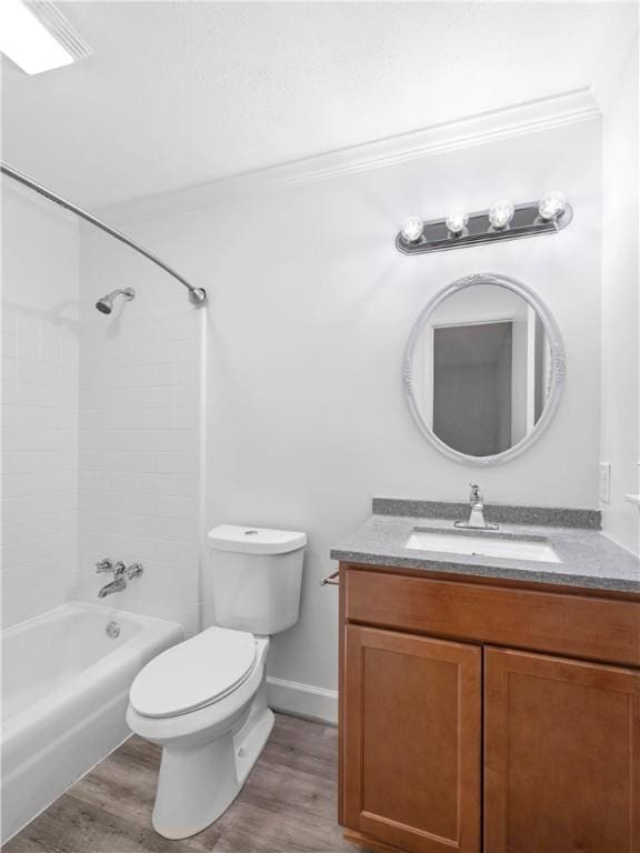 full bathroom with vanity, crown molding, washtub / shower combination, hardwood / wood-style floors, and toilet