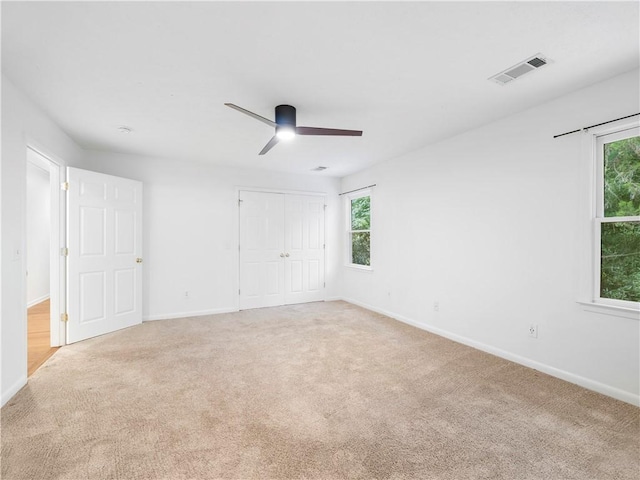 carpeted spare room with ceiling fan