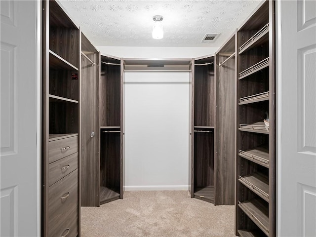 spacious closet with wine cooler and light colored carpet