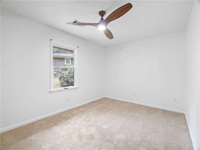 carpeted spare room with ceiling fan