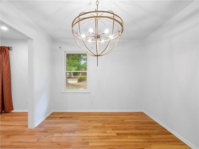 unfurnished dining area featuring a chandelier and light hardwood / wood-style flooring