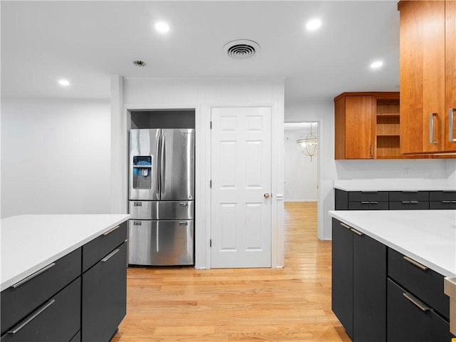 kitchen with light hardwood / wood-style flooring, a chandelier, and stainless steel refrigerator with ice dispenser