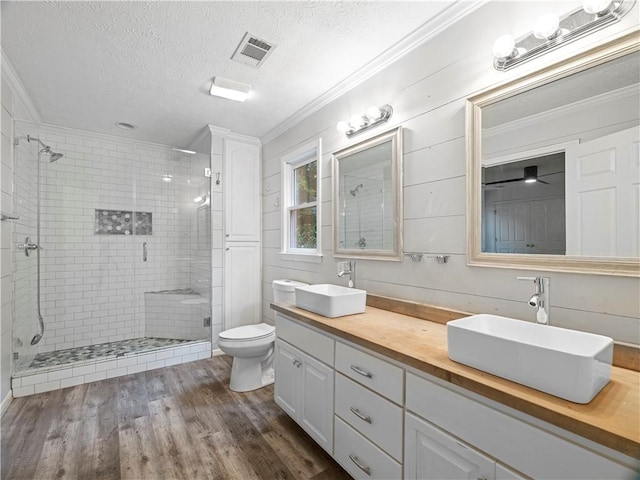 bathroom featuring crown molding, hardwood / wood-style flooring, a textured ceiling, and toilet