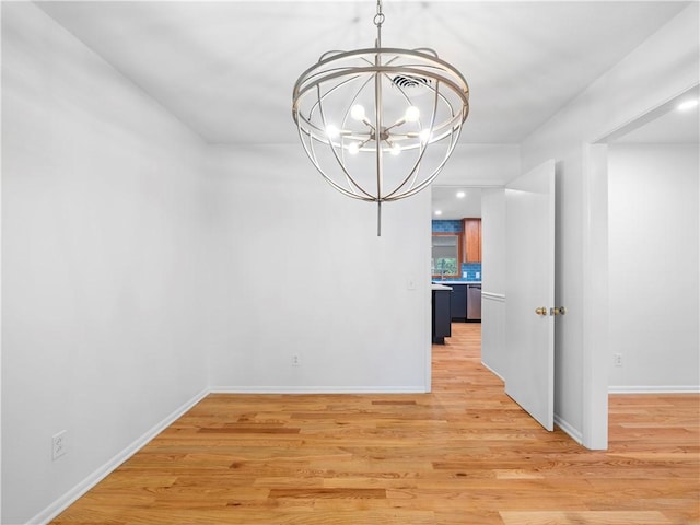 unfurnished dining area with light wood-type flooring and an inviting chandelier