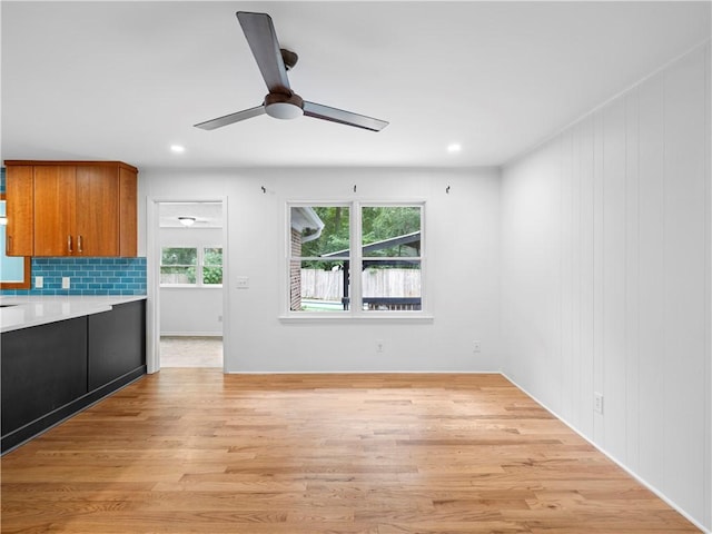 kitchen with ceiling fan, light hardwood / wood-style floors, and tasteful backsplash