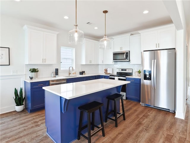016 Crossing Ct E, Valley, AL 36854 - kitchen with appliances with stainless steel finishes, blue cabinetry, a sink, a kitchen bar, and recessed lighting