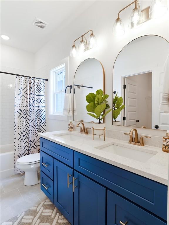 016 Crossing Ct E, Valley, AL 36854 - bathroom featuring double vanity, toilet, shower / bath combo with shower curtain, and tile patterned flooring