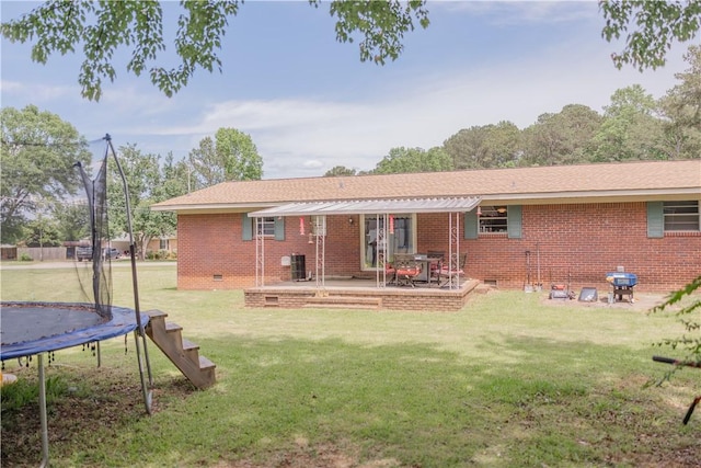 2401 11th Ave, Valley, AL 36854 - back of house with a trampoline, crawl space, a lawn, and brick siding