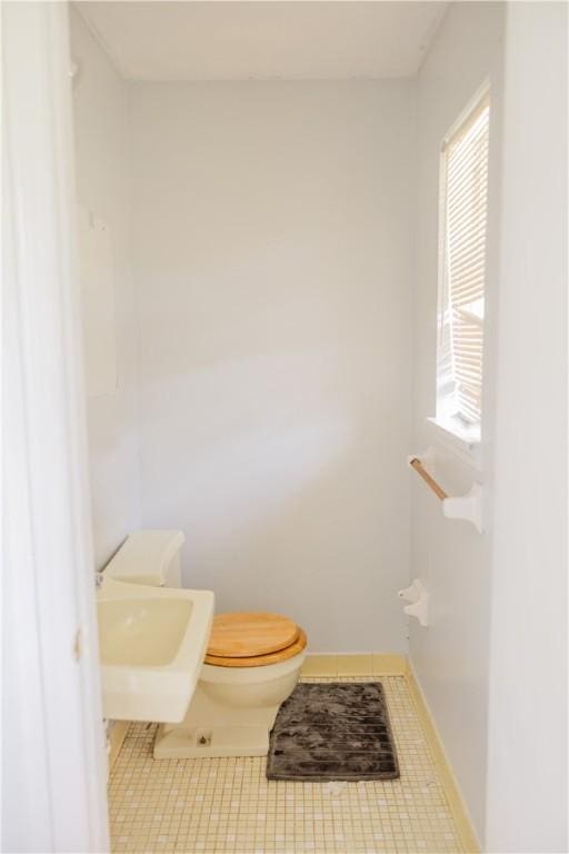 2401 11th Ave, Valley, AL 36854 - bathroom featuring tile patterned floors, toilet, a sink, and baseboards