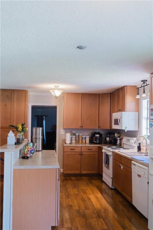 2401 11th Ave, Valley, AL 36854 - kitchen featuring white appliances, light countertops, a textured ceiling, dark wood-style flooring, and a sink