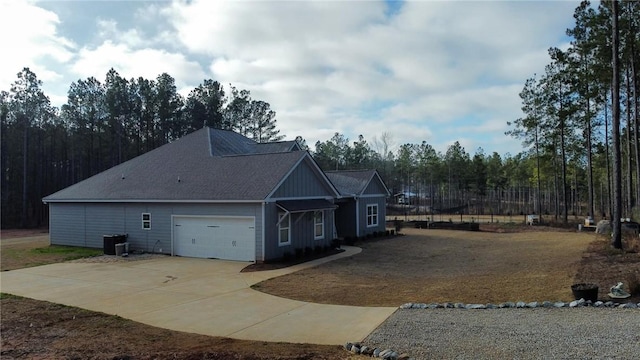 view of side of property with a garage and central AC