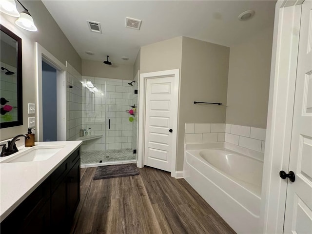 bathroom featuring vanity, wood-type flooring, and shower with separate bathtub