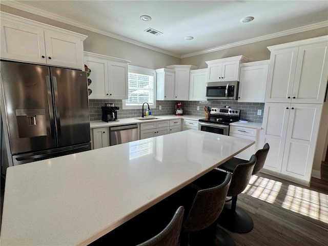 kitchen featuring white cabinets, sink, stainless steel appliances, and tasteful backsplash