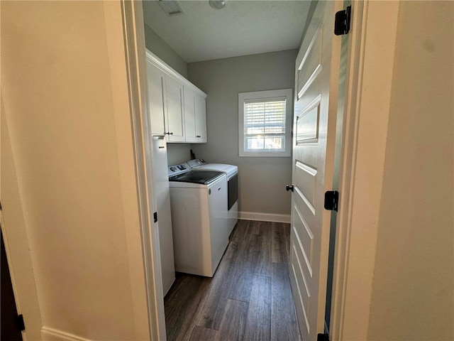 laundry area with washer and dryer, cabinets, and dark wood-type flooring